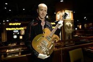 Matin Nolan, o diretor executivo da Julien's Auction's, segura a rara guitarra VOX, tocada por John Lennon e George Harrison (AFP/Timothy Clary)