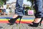 Blumenau-sc-Brasil, Ato público contra homofobia no jardim do teatro Carlos Gomes- Rodrigo Kalbusch de salto alto passa em frente a bandeira simbolo gay