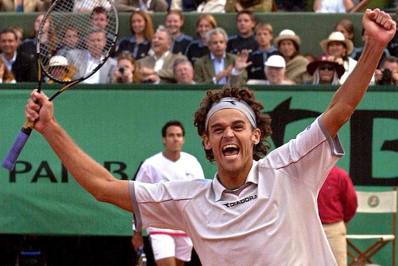 Brazilian Gustavo Kuerten celebrates after winning the men's singles final against Spanish Alex Corretja (back) 10 June 2001, at the French Tennis Open in Roland Garros, Paris. Top seed and defending champion Kuerten won the title for the third time, defeating 13th seed Alex Corretja 6-7 (3/7), 7/5, 6-2, 6-0.        AFP PHOTO/PASCAL GEORGE Fonte: AFP Fotógrafo: PASCAL GEORGE