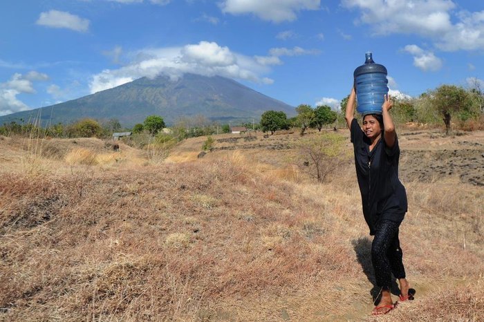 A woman carries water on her head in the Kubu subdistrict of Karangasem Regency on the Indonesian resort island of Bali on September 26, 2017, as Mount Agung volcano looms in the background.
More than 57,000 people have fled a volcano on the tourist island of Bali as rising magma and increased tremors fuel fears of an imminent eruption, officials said on September 26. / AFP PHOTO / SONNY TUMBELAKA
Editoria: DIS
Local: Karangasem
Indexador: SONNY TUMBELAKA
Secao: volcanic eruption
Fonte: AFP
Fotógrafo: STR
A woman carries water on her head in the Kubu subdistrict of Karangasem Regency on the Indonesian resort island of Bali on September 26, 2017, as Mount Agung volcano looms in the background.
More than 57,000 people have fled a volcano on the tourist island of Bali as rising magma and increased tremors fuel fears of an imminent eruption, officials said on September 26. / AFP PHOTO / SONNY TUMBELAKA
Editoria: DIS
Local: Karangasem
Indexador: SONNY TUMBELAKA
Secao: volcanic eruption
Fonte: AFP
Fotógrafo: STR