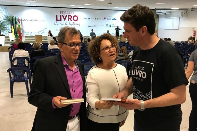 Dezenas de palestras, painéis, conversas, contação de históricas, espetáculos musicais e artísticos, lançamento de livros, marcam a Feira do Livro de Rio do Sul, que se encerra neste fim de semana. O evento envolveu os meios acadêmicos e parte da população, com ampla e moderna comunicação visual no Parque Universitário da Unidavi e no centro da cidade. Iniciativa da fundação Cultural e organização da promotora Sueli Brandão (C), na foto com o escritor Deonisio da Silva (E) e o prefeito José Thomé(D). Dezenas de palestras, painéis, conversas, contação de históricas, espetáculos musicais e artísticos, lançamento de livros, marcam a Feira do Livro de Rio do Sul, que se encerra neste fim de semana. O evento envolveu os meios acadêmicos e parte da população, com ampla e moderna comunicação visual no Parque Universitário da Unidavi e no centro da cidade. Iniciativa da fundação Cultural e organização da promotora Sueli Brandão (C), na foto com o escritor Deonisio da Silva (E) e o prefeito José Thomé(D).