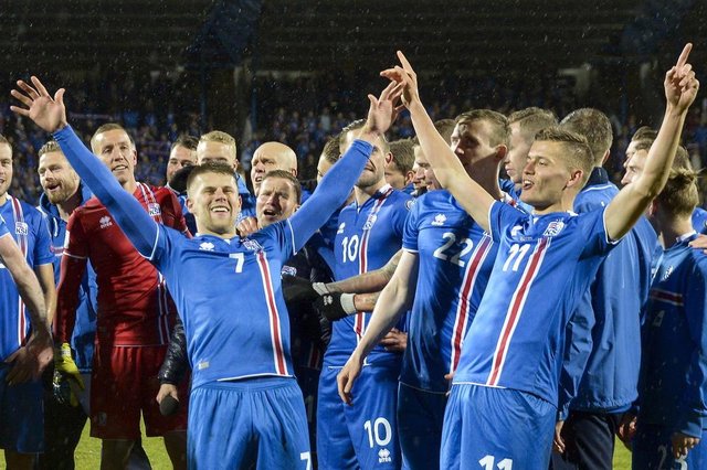 Iceland's players including Iceland's forward Johann Berg Gudmundsson (L) and Iceland's forward Alfred Finnbogason celebrate after the FIFA World Cup 2018 qualification football match between Iceland and Kosovo in Reykjavik, Iceland on October 9, 2017.Iceland qualified for the FIFA World Cup 2018 as smallest country ever after beating Kosovo 2-0 at home in Reykjavik. / AFP PHOTO / Haraldur Gudjonsson / ALTERNATIVE CROP 