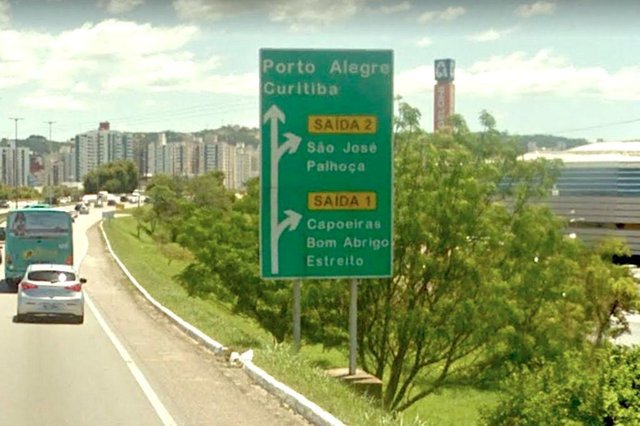 Pois é, eu também quase não acreditei no que vi. O leitor Marcos Aliberti me enviou essa foto feita na manhã de ontem na Via Expressa, próximo ao Bairro Capoeiras, da nova placa de sinalização que (substituiu uma antiga) e orienta para as duas saídas à direita - para quem vai para a Capoeiras/Estreito (Saída 1), ou para São João/Palhoça (Saída 2). Ops! SÃO JOÃO? Será que o vizinho município mudou de nome e não avisaram ninguém? Caso positivo, a Prefeita Adeliana Dal Ponte vai ter que encaminhar um Projeto à Câmara para mudar o nome da cidade para São João da Terra Firme, não é? Mas, acho mais fácil o DNIT assumir o erro e consertar rapidamente a placa. Seria cômico se não fosse trágico. Pois é, eu também quase não acreditei no que vi. O leitor Marcos Aliberti me enviou essa foto feita na manhã de ontem na Via Expressa, próximo ao Bairro Capoeiras, da nova placa de sinalização que (substituiu uma antiga) e orienta para as duas saídas à direita - para quem vai para a Capoeiras/Estreito (Saída 1), ou para São João/Palhoça (Saída 2). Ops! SÃO JOÃO? Será que o vizinho município mudou de nome e não avisaram ninguém? Caso positivo, a Prefeita Adeliana Dal Ponte vai ter que encaminhar um Projeto à Câmara para mudar o nome da cidade para São João da Terra Firme, não é? Mas, acho mais fácil o DNIT assumir o erro e consertar rapidamente a placa. Seria cômico se não fosse trágico.