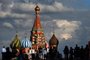 People walk along the Red Square toward to St Basils Cathedral (background) in Moscow on July 11, 2016.  / AFP PHOTO / VASILY MAXIMOV