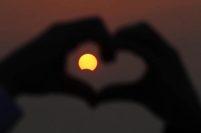 ciência, eclipse, solar, kuwaitA Kuwaiti man makes the outline of a heart with his fingers to encompass a partially solar eclipse at Souq Sharq Marina in Kuwait City on November 3, 2013. A rare solar eclipse will sweep across parts of Africa, Europe and the United States as the moon blocks the sun either fully or partially, depending on the location. AFP PHOTO/YASSER AL-ZAYYAT ciência, eclipse, solar, kuwaitA Kuwaiti man makes the outline of a heart with his fingers to encompass a partially solar eclipse at Souq Sharq Marina in Kuwait City on November 3, 2013. A rare solar eclipse will sweep across parts of Africa, Europe and the United States as the moon blocks the sun either fully or partially, depending on the location. AFP PHOTO/YASSER AL-ZAYYAT