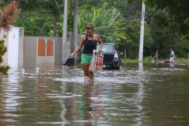 FLORIANÓPOLIS , SC, BRASIL 11/01/2018 .ENXURRADA :Mulher carregando cadeira de praia: Turista argentina, Eugenia Brandan, de Tucuman, veio com 9 pessoas da família e seu filho de 2 anos pelo terceiro ano consecutivo. Já estivemos aqui nos outros anos e nunca vimos nada parecido. Nossos carros ficaram totalmente cheios de água. Mas vou aproveitar agora e dar um pulo na praia porque não há o que fazer. Ela está hospedada em uma casa alugada, na Travessa Pinguin, no Campeche. FLORIANÓPOLIS , SC, BRASIL 11/01/2018 .ENXURRADA :Mulher carregando cadeira de praia: Turista argentina, Eugenia Brandan, de Tucuman, veio com 9 pessoas da família e seu filho de 2 anos pelo terceiro ano consecutivo. Já estivemos aqui nos outros anos e nunca vimos nada parecido. Nossos carros ficaram totalmente cheios de água. Mas vou aproveitar agora e dar um pulo na praia porque não há o que fazer. Ela está hospedada em uma casa alugada, na Travessa Pinguin, no Campeche.