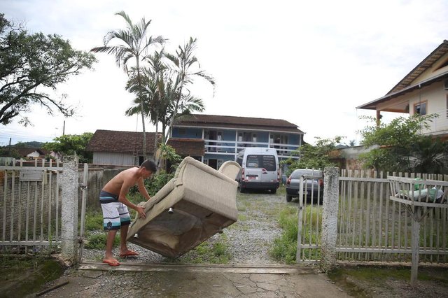 JOINVILLE, SC, BRASIL - 18/01/2018Efeitos da chuva em Joinville no bairro Vila Nova. Na foto, Cláudio Cubas retira um sofá molhado da sua casa no bairro Vila Nova JOINVILLE, SC, BRASIL - 18/01/2018Efeitos da chuva em Joinville no bairro Vila Nova. Na foto, Cláudio Cubas retira um sofá molhado da sua casa no bairro Vila Nova