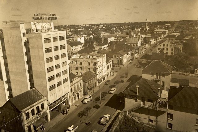 Vista da Av. Júlio de Castilhos no final dos anos 1960. À esquerda, vê-se o prédio da loja Casa Prataviera. Mais ao fundo, a Igreja Metodista e a Igreja de São Pelegrino, respectivamente. Também vemos o prédio dos Armarinhos Caxias (ao lado do prédio, hoje sede das Casas Uruguai) e o Edifício Caberlon, quase na esquina com a Rua Garibaldi. Vista da Av. Júlio de Castilhos no final dos anos 1960. À esquerda, vê-se o prédio da loja Casa Prataviera. Mais ao fundo, a Igreja Metodista e a Igreja de São Pelegrino, respectivamente. Também vemos o prédio dos Armarinhos Caxias (ao lado do prédio, hoje sede das Casas Uruguai) e o Edifício Caberlon, quase na esquina com a Rua Garibaldi.