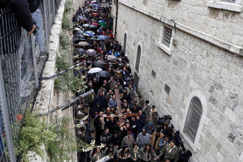  Christian pilgrims carry a large wooden cross along the Via Dolorosa (Way of Suffering) in Jerusalems Old City during the Good Friday procession on March 30, 2018.Thousands of Christian pilgrims take part in processions along the route where according to tradition Jesus Christ carried the cross during his last days, as Christians around the world mark the Holy Week commemorating the crucifixion of Jesus Christ leading up to his resurrection on Easter. / AFP PHOTO / AHMAD GHARABLIEditoria: RELLocal: JerusalemIndexador: AHMAD GHARABLISecao: christianityFonte: AFPFotógrafo: STF