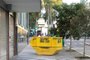 Caçamba para recolher resíduos da construção civil bem no meio de calçada da Avenida Júlio de Castilhos, a 10 metros da Praça Dante Alihgieri, restringe espaço de pedestres e cadeirantes.