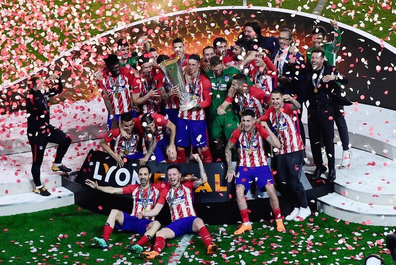 Atletico Madrids Spanish forward Fernando Torres (C) holds the trophy past teammates after winning the UEFA Europa League final football match between Olympique de Marseille and Club Atletico de Madrid at the Parc OL stadium in Decines-Charpieu, near Lyon on May 16, 2018.Atletico won 3-0. / AFP PHOTO / Jean-Philippe KSIAZEK