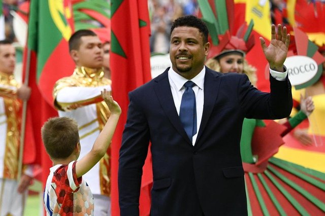 Brazilian football ledgend Ronaldo (R) waves during the opening ceremony before the Russia 2018 World Cup Group A football match between Russia and Saudi Arabia at the Luzhniki Stadium in Moscow on June 14, 2018. / AFP PHOTO / Alexander NEMENOV / RESTRICTED TO EDITORIAL USE - NO MOBILE PUSH ALERTS/DOWNLOADSEditoria: SPOLocal: MoscowIndexador: ALEXANDER NEMENOVSecao: soccerFonte: AFPFotógrafo: STF Brazilian football ledgend Ronaldo (R) waves during the opening ceremony before the Russia 2018 World Cup Group A football match between Russia and Saudi Arabia at the Luzhniki Stadium in Moscow on June 14, 2018. / AFP PHOTO / Alexander NEMENOV / RESTRICTED TO EDITORIAL USE - NO MOBILE PUSH ALERTS/DOWNLOADSEditoria: SPOLocal: MoscowIndexador: ALEXANDER NEMENOVSecao: soccerFonte: AFPFotógrafo: STF
