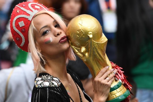 A Russian fan kisses a replica of the FIFA 2018 World Cup trophy before the Russia 2018 World Cup Group A football match between Russia and Saudi Arabia at the Luzhniki Stadium in Moscow on June 14, 2018. / AFP PHOTO / Kirill KUDRYAVTSEV / RESTRICTED TO EDITORIAL USE - NO MOBILE PUSH ALERTS/DOWNLOADSEditoria: SPOLocal: MoscowIndexador: KIRILL KUDRYAVTSEVSecao: soccerFonte: AFPFotógrafo: STF A Russian fan kisses a replica of the FIFA 2018 World Cup trophy before the Russia 2018 World Cup Group A football match between Russia and Saudi Arabia at the Luzhniki Stadium in Moscow on June 14, 2018. / AFP PHOTO / Kirill KUDRYAVTSEV / RESTRICTED TO EDITORIAL USE - NO MOBILE PUSH ALERTS/DOWNLOADSEditoria: SPOLocal: MoscowIndexador: KIRILL KUDRYAVTSEVSecao: soccerFonte: AFPFotógrafo: STF