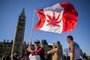 (FILES) In this file photo taken on April 20, 2016 showing a woman waving a flag with a marijuana leef on it next to a group gathered to celebrate National Marijuana Day on Parliament Hill in Ottawa, Canada.Canada lawmakers voted to legalize cannabis on June 18, 2018. / AFP PHOTO / Chris Roussakis