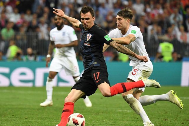 Croatias forward Mario Mandzukic scores his teams second goal past Englands defender John Stones (R) during the Russia 2018 World Cup semi-final football match between Croatia and England at the Luzhniki Stadium in Moscow on July 11, 2018. / AFP PHOTO / YURI CORTEZ / RESTRICTED TO EDITORIAL USE - NO MOBILE PUSH ALERTS/DOWNLOADSEditoria: SPOLocal: MoscowIndexador: YURI CORTEZSecao: soccerFonte: AFPFotógrafo: STF Croatias forward Mario Mandzukic scores his teams second goal past Englands defender John Stones (R) during the Russia 2018 World Cup semi-final football match between Croatia and England at the Luzhniki Stadium in Moscow on July 11, 2018. / AFP PHOTO / YURI CORTEZ / RESTRICTED TO EDITORIAL USE - NO MOBILE PUSH ALERTS/DOWNLOADSEditoria: SPOLocal: MoscowIndexador: YURI CORTEZSecao: soccerFonte: AFPFotógrafo: STF