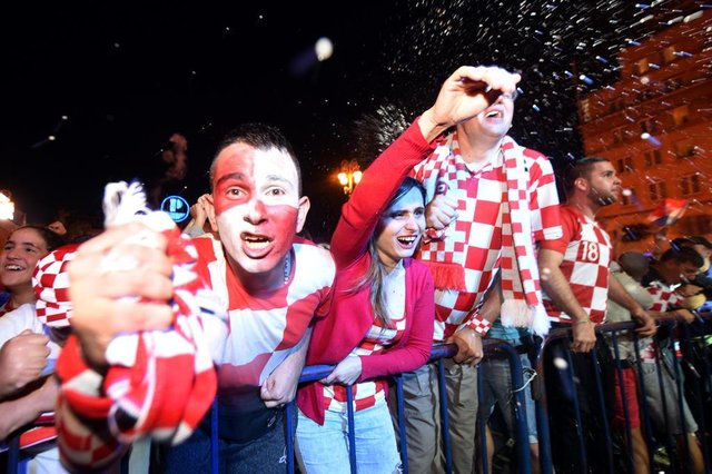 Croatias supporters celebrate after a goal as they watch on a giant screen the Russia 2018 World Cup semi-final football match between Croatia and England, at the main square in Zagreb on July 11, 2018. / AFP PHOTO / Denis Lovrovic Croatias supporters celebrate after a goal as they watch on a giant screen the Russia 2018 World Cup semi-final football match between Croatia and England, at the main square in Zagreb on July 11, 2018. / AFP PHOTO / Denis Lovrovic