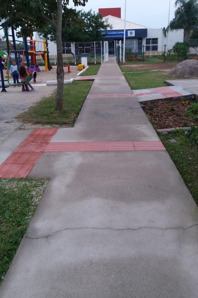 Ma chamo Cleide Franciani da Silva, moradora do bairro Tapera. Sou deficiente visual, tenho baixa visão. Gostaria de relatar algo que me incomoda e me preocupa. Mês passado a Prefeitura de Florianópolis entregou a reforma do Centro de Saúde aqui do bairro, mas deixou um grave problema no piso guia que é utilizado por nós. Como mostro na fotos, o piso da maneira que está pode causar acidentes, pois guia os deficientes visuais para fora da calçada e sem nenhuma proteção. Tive oportunidade de conversar pessoalmente com o prefeito Gean no local, ele ficou de mandar arrumar, mas até agora nenhuma providência foi tomada. Gostaria que esse erro fosse corrigido. Obrigado pela atenção. Ma chamo Cleide Franciani da Silva, moradora do bairro Tapera. Sou deficiente visual, tenho baixa visão. Gostaria de relatar algo que me incomoda e me preocupa. Mês passado a Prefeitura de Florianópolis entregou a reforma do Centro de Saúde aqui do bairro, mas deixou um grave problema no piso guia que é utilizado por nós. Como mostro na fotos, o piso da maneira que está pode causar acidentes, pois guia os deficientes visuais para fora da calçada e sem nenhuma proteção. Tive oportunidade de conversar pessoalmente com o prefeito Gean no local, ele ficou de mandar arrumar, mas até agora nenhuma providência foi tomada. Gostaria que esse erro fosse corrigido. Obrigado pela atenção.