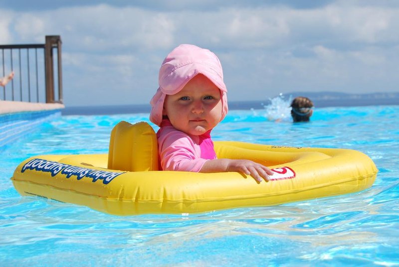bebê dentro de uma boia na piscina
