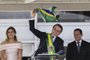  Brazils new President Jair Bolsonaro (C) waves a Brazilian national flag next to First Lady Michelle Bolsonaro (L) and Brazils new Vice-President Hamilton Mourao, during their inauguration ceremony at Planalto Palace in Brasilia on January 1, 2019. - Bolsonaro takes office with promises to radically change the path taken by Latin Americas biggest country by trashing decades of centre-left policies. (Photo by EVARISTO SA / various sources / AFP)Editoria: POLLocal: BrasíliaIndexador: EVARISTO SASecao: governmentFonte: EVARISTO SAFotógrafo: STF
