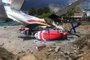  A Summit Air Let L-410 Turbolet aircraft bound for Kathmandu is seen after it hit two helicopters during take off at Lukla airport, the main gateway to the Everest region. - A small plane veered off the runway and hit two helicopters while taking off near Mount Everest on April 14, killing three people and injuring three, officials said. (Photo by STR / AFP)Editoria: DISLocal: EverestIndexador: STRSecao: accident (general)Fonte: AFPFotógrafo: STR