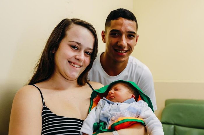 Os pais, Fabrício e Rithyelen, são só sorrisos com o filho, Caio, vestido de cenourinha