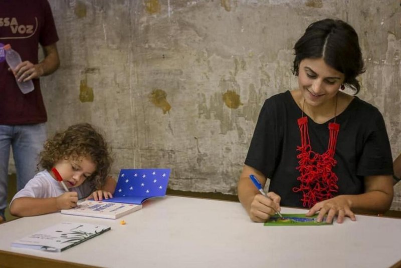 Manuela DÁvila (PCdoB) com a filha Laura autografando o livro Revolução Laura em abril, na USP, em São Paulo. 