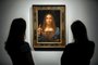 (FILES) In this file photo taken on October 24, 2017 Christies employees pose in front of a painting entitled Salvator Mundi by Italian polymath Leonardo da Vinci at a photocall at Christies auction house in central London ahead of its sale at Christies New York on November 15, 2017. - Later this year, the Louvre museum in Paris will host an exhibition grouping masterpieces of the great Italian painter Leonardo da Vinci to mark his death 500 years ago in France.The Salvator Mundi, sold at auction as a work by Leonardo for a record $450 million dollars in 2017, has not been displayed in public since, as doubts swirl about its ownership, whereabouts and authenticity. (Photo by Tolga Akmen / AFP) / RESTRICTED TO EDITORIAL USE - MANDATORY MENTION OF THE ARTIST UPON PUBLICATION - TO ILLUSTRATE THE EVENT AS SPECIFIED IN THE CAPTION