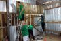 Caixas de leite são usadas para forrar casas de madeira em Caxias