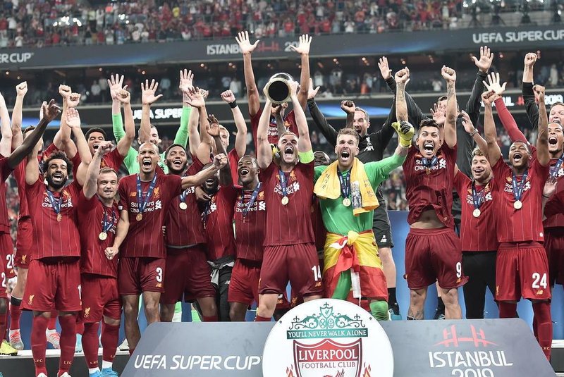 Liverpool team poses with the trophy after winning the UEFA Super Cup 2019 football match between FC Liverpool and FC Chelsea at Besiktas Park Stadium in Istanbul on August 14, 2019. (Photo by OZAN KOSE / AFP)