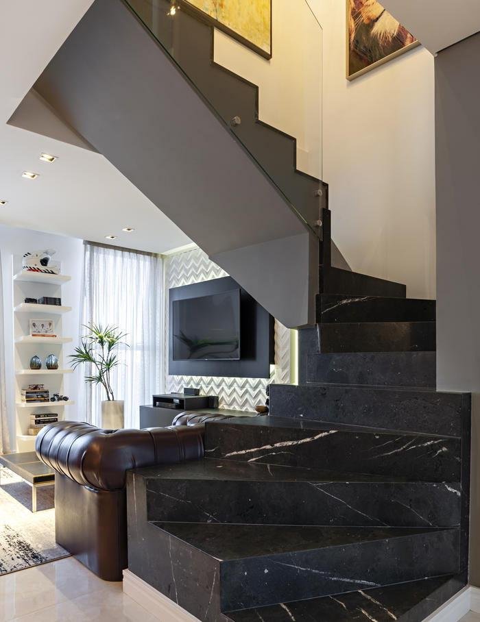 Escadaria: revestida em granito Kouros escovado, tem corrimão em vidro transparente. No térreo, destaca-se o home theater