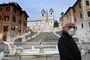 A man wearing a protection mask walks by the Spanish Steps at a deserted Piazza di Spagna in central Rome on March 12, 2020, as Italy shut all stores except for pharmacies and food shops in a desperate bid to halt the spread of a coronavirus. (Photo by Alberto PIZZOLI / AFP)