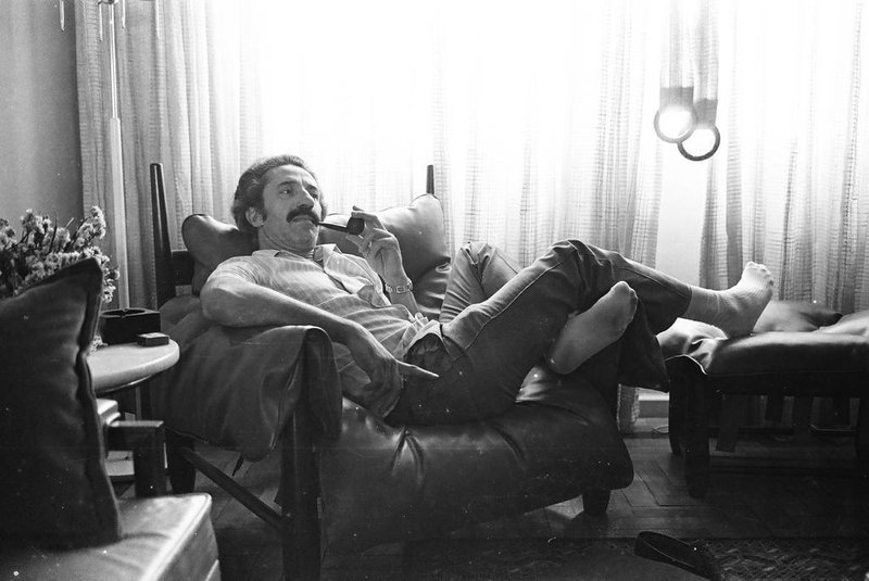 Anos 1970: o fotógrafo Mauro De Blanco e o indefectível cachimbo durante um momento relax em sua clássica Poltrona Mole, ícone do moderno mobiliário brasileiro, assinado por Sergio Rodrigues<!-- NICAID(14473727) -->