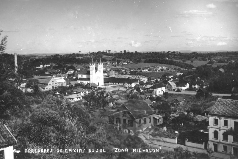 Panorâmica do bairro Lourdes nos anos 1950, a partir dos altos da Rua Pinheiro Machado. Vê-se a Avenida Júlio de Castilhos, o casarão de madeira de Vicente Rovea (ao centro), a Casa de Negócios de Vicente Rovea à direita  (antigo Hospital Carbone e atual sede do Arquivo Histórico Municipal João Spadari Adami), a Igreja de Nossa Senhora de Lourdes e parte da Vinícola Luiz Michiielon, com a antiga chaminé.<!-- NICAID(14485363) -->