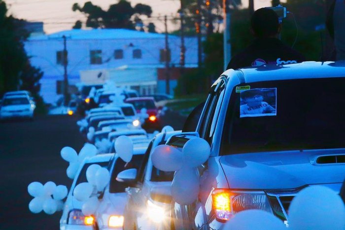 Balões e retratos do menino foram colocados nos carros