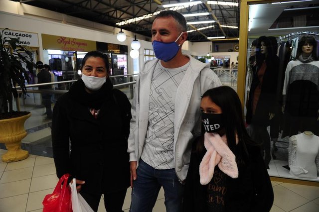 FARROUPILHA, RS, BRASIL, 25/05/2020. Centro de Compras de Farroupilha registra queda no público, composto por consumidores finais e varejistas. Medidas como a esterilização das roupas com vapor foram adotadas para que os clientes possam continuar provando antes de comprar. De Novo Hamburgo, Sônia de Barros Vieira, 42, Valmir Ferrari, 43, e a filha do casal, Rafaela Vieira Ferrari, 8, aproveitaram a folga no restaurante onde trabalham para passear e fazer compras no shopping de Farroupilha. (Porthus Junior/Agência RBS)<!-- NICAID(14507646) --> FARROUPILHA, RS, BRASIL, 25/05/2020. Centro de Compras de Farroupilha registra queda no público, composto por consumidores finais e varejistas. Medidas como a esterilização das roupas com vapor foram adotadas para que os clientes possam continuar provando antes de comprar. De Novo Hamburgo, Sônia de Barros Vieira, 42, Valmir Ferrari, 43, e a filha do casal, Rafaela Vieira Ferrari, 8, aproveitaram a folga no restaurante onde trabalham para passear e fazer compras no shopping de Farroupilha. (Porthus Junior/Agência RBS)<!-- NICAID(14507646) -->