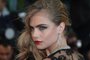 British model Cara Delevingne poses on May 15, 2013 as she arrives for the screening of The Great Gatsby ahead of the opening of the 66th edition of the Cannes Film Festival in Cannes. Cannes, one of the worlds top film festivals, opens on May 15 and will climax on May 26 with awards selected by a jury headed this year by Hollywood legend Steven Spielberg.      AFP PHOTO / ALBERTO PIZZOLI<!-- NICAID(9382412) -->