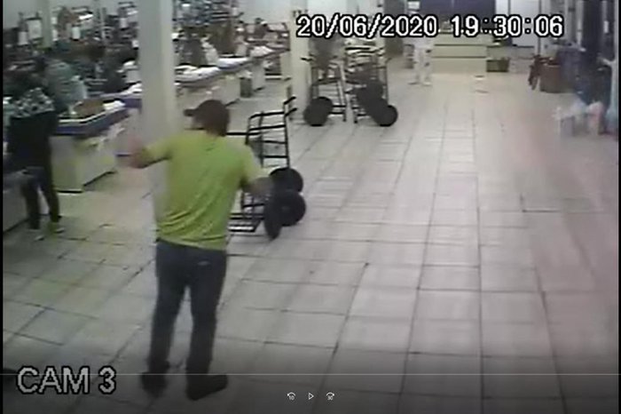 Nesta imagem, aparece uma mão segurando uma arma em direção ao cliente