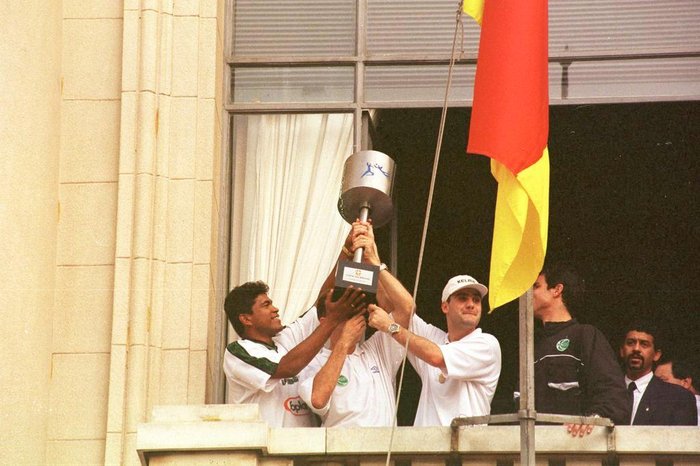 Mabília e índio com o troféu na sacada do Palácio Piratini