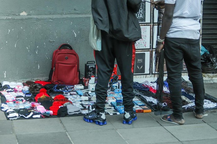Muitos ambulantes utilizam as portas das lojas fechadas para expor as mercadorias