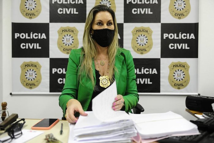Delegada Adriana Regina da Costa, com documentos dos casos investigados