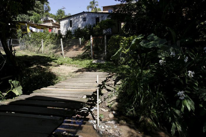 Moradores improvisam travessias sobre o Arroio Moinho, na Zona Leste