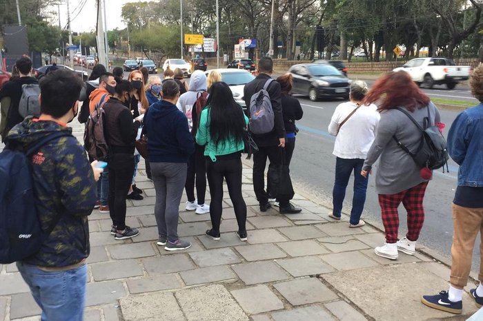 Passageiros à espera dos coletivos, que circulam com atraso