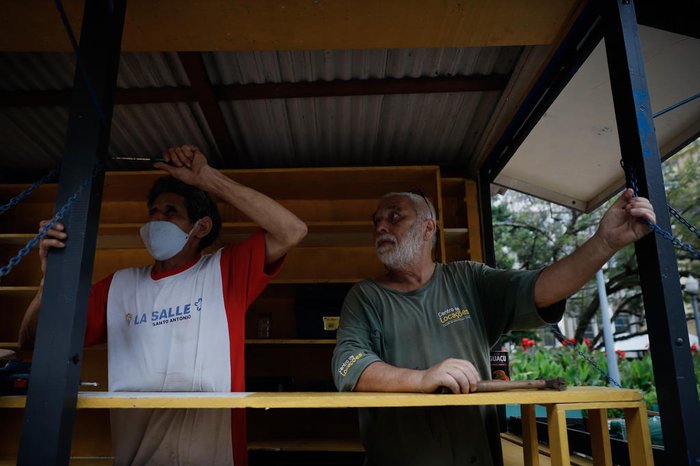 Equipes trabalham na montagem das bancas