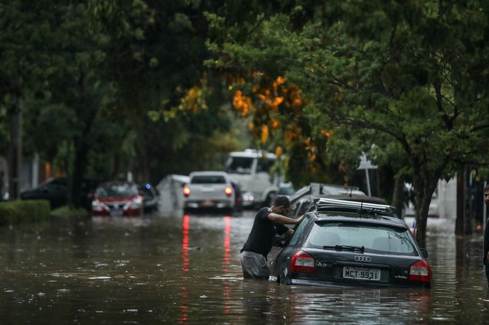 Motoristas precisaram entrar na água para acessar os veículos