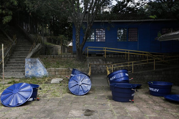 Na manhã desta quarta-feira (23), equipes da prefeitura recolhiam do pátio da escola caixas d'água para entrega a famílias