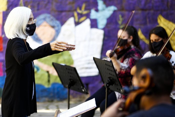 Cecília (de pé) fica na regência da orquestra