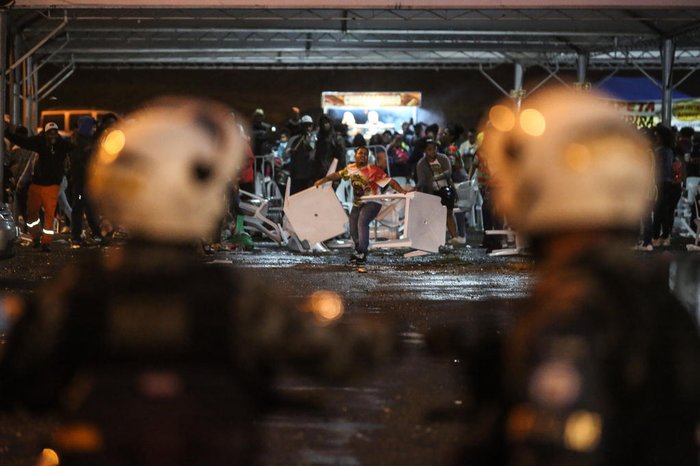 Policiais militares observam tumulto
