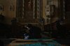 Uma mulher confecciona  um tapete  na parte interna  da  Igreja Nossa Senhora das Dores