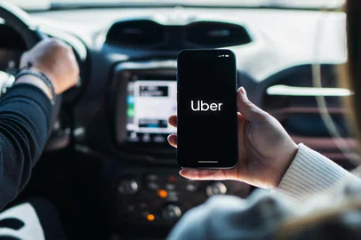 Girl inside car holding smartphone with Uber app on screen. Rio de Janeiro, RJ, Brazil. August 2022.Fonte: 525383591<!-- NICAID(15541625) -->