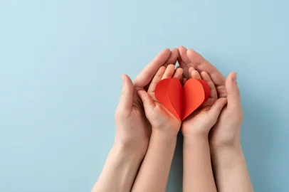 ActionGP / stock.adobe.com Image depicting adult and child hands holding a red heart, representing love, care, and family bonds. Foto: ActionGP / stock.adobe.comFonte: 1407671418<!-- NICAID(16162711) -->